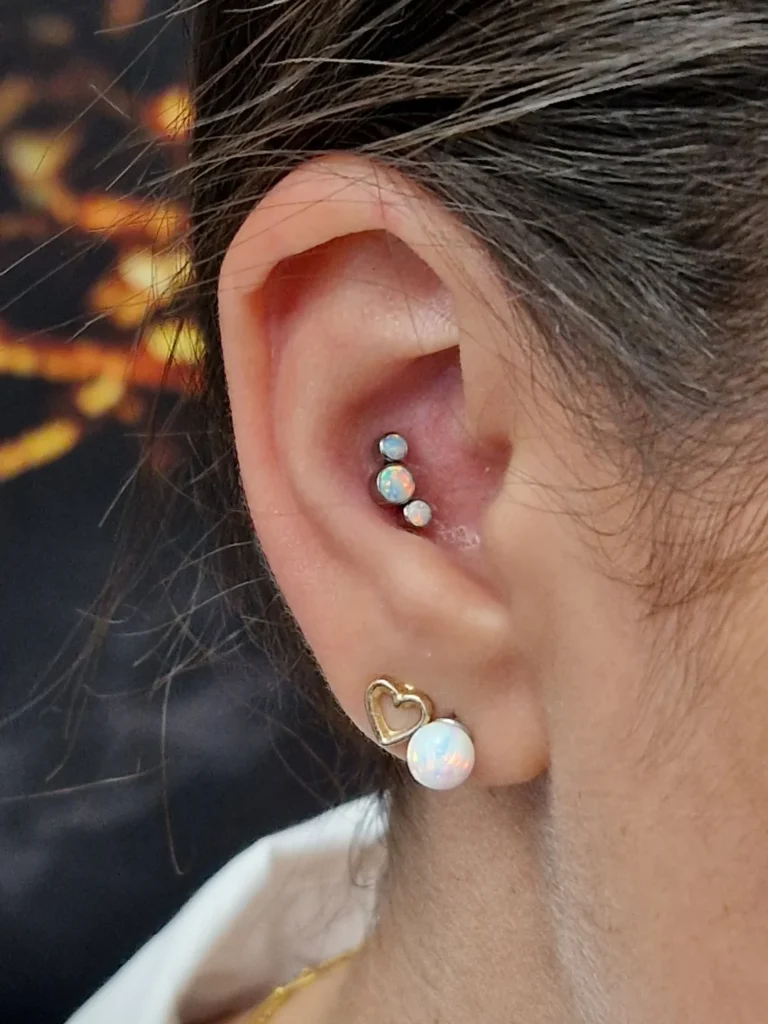 Piercing v uchu, conch piercing s opalovými kamínky